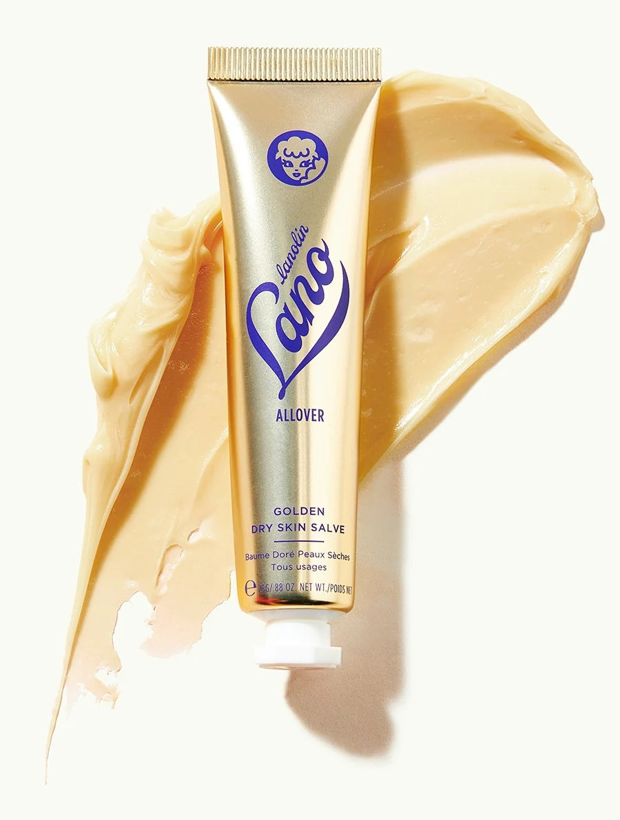 A gold tube of LANOLIPS - GOLDEN DRY SKIN MIRACLE SALVE from LANOLIPS, featuring blue text and a white cap. The label states “Made with Love and Lanolin” and describes it as an intensive hydration ointment for all-over use on dry skin.