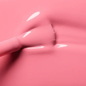 A hand with short, neatly manicured nails painted with MANUCURIST - GREEN™ Nail Polish in Pink Paradise by MANUCURIST INC rests on a cream-colored knitted fabric.