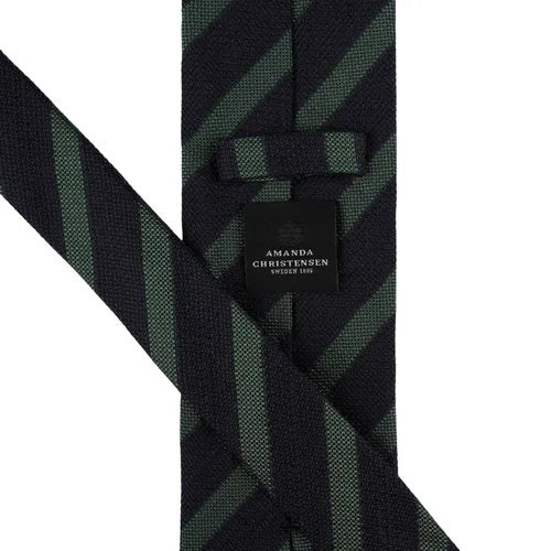 The AMANDA CHRISTENSEN Striped Jacquard Woven Silk Tie in Green showcases refined Italian craftsmanship with diagonal black and dark green stripes on a crisp white background, making it a sophisticated accessory that enhances any gentleman’s wardrobe.