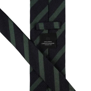 The AMANDA CHRISTENSEN Striped Jacquard Woven Silk Tie in Green showcases refined Italian craftsmanship with diagonal black and dark green stripes on a crisp white background, making it a sophisticated accessory that enhances any gentleman’s wardrobe.