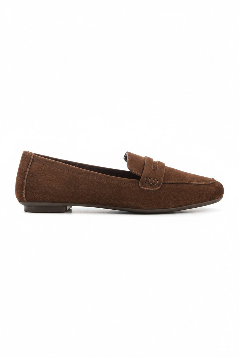 The REQINS HEMA suede loafer in cacao features moccasin-style stitching, a penny strap, and a low black heel for stylish comfort, showcased on a light background.