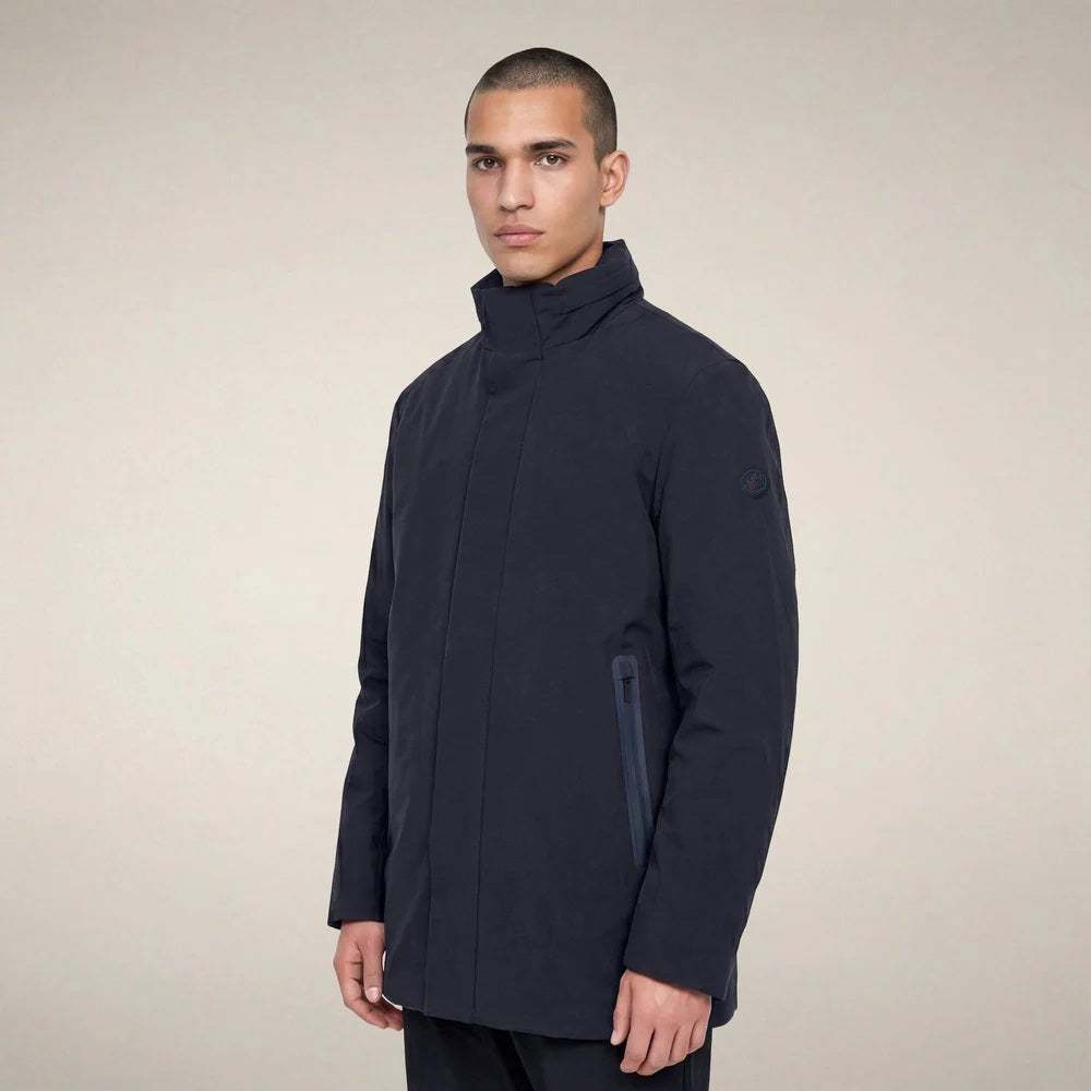 A man wears a dark blue SAVE THE DUCK - BLAISE JACKET IN BLUE BLACK with a high neck and a zippered chest pocket.
