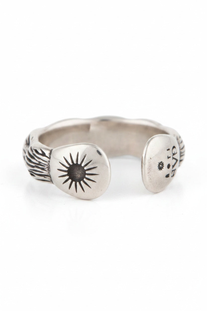 The GAS BIJOUX - SILVER LIANE JONC BIS RING, crafted by GAS BIJOUX, showcases a stunning bamboo motif with intricate engraved designs on the interior. It easily adjusts to fit you perfectly and is presented on a simple beige background with a delicate shadow beneath.