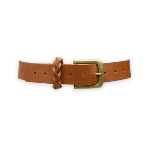 The ADA TOUGH GUY BELT is a handcrafted piece featuring Argentinian brown leather, a brass buckle, and a braided keeper. It includes multiple holes for sizing adjustments and is showcased on a plain white background.