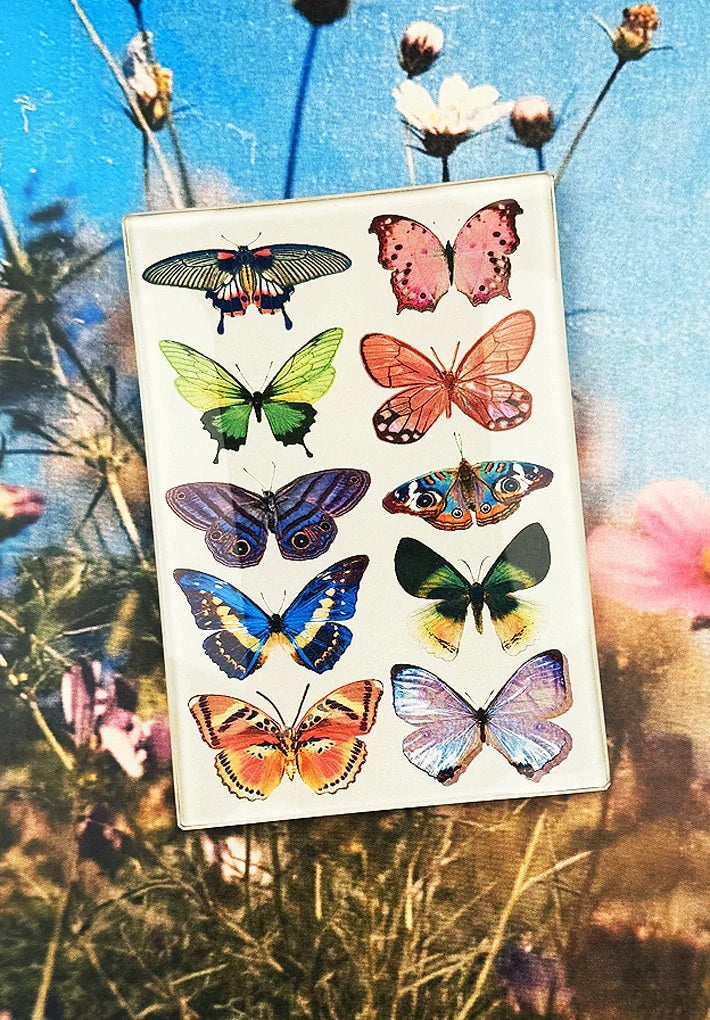 Ten vibrant butterflies, each with unique patterns and hues of green, pink, blue, orange, yellow, brown, and purple wings, are artfully arranged in two columns on a soft beige background. This exquisite design is beautifully showcased on the BEN’S GARDEN - WILDFLOWER BUTTERFLIES DECOUPAGE GLASS TRAY by BENS GARDEN—a handcrafted decoupage piece that captures every detail with elegance.