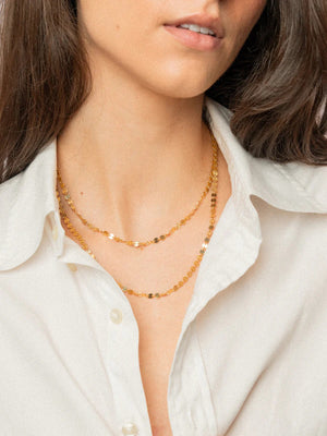 The KENDA KIST - MYKONOS LONG LAYER NECKLACE by KENDA KIST is a 14k gold filled disc chain with elegant circles, ideal for layering as a stylish accessory.