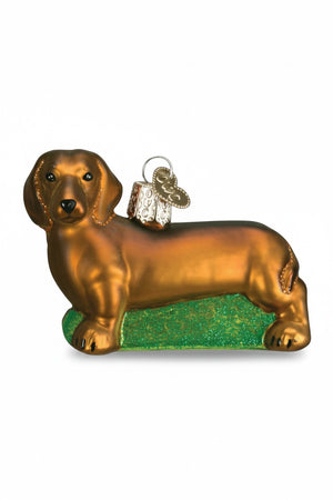 DACHSUND CHRISTMAS ORNAMENT shaped like an affectionate brown dachshund standing on a green, glittery base.