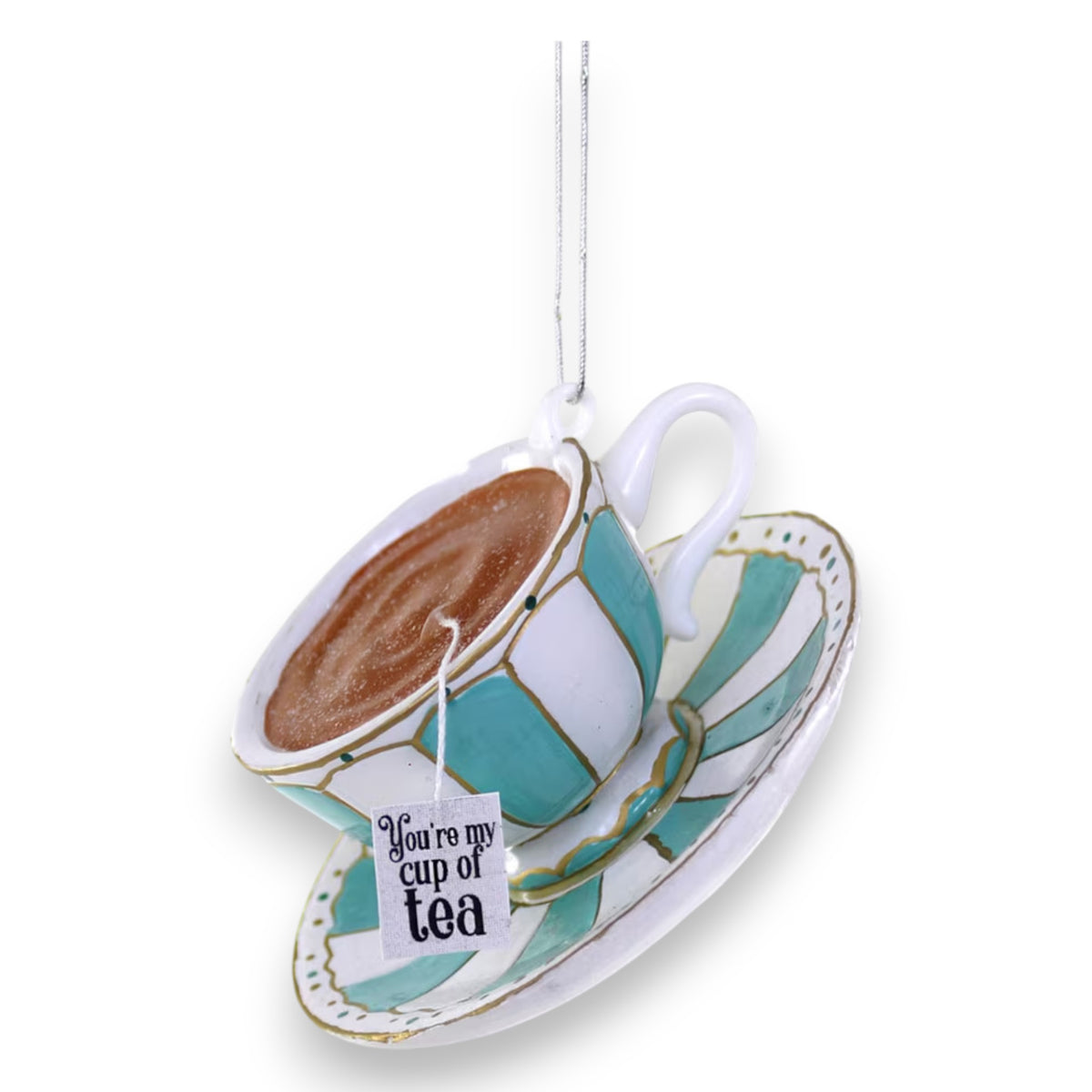 The CODY FOSTER YOU&#39;RE MY CUP OF TEA ORNAMENT features a teal and white teacup and saucer with a &quot;You&#39;re my cup of tea&quot; tag, hanging by a string—perfect for gifting or design lovers.