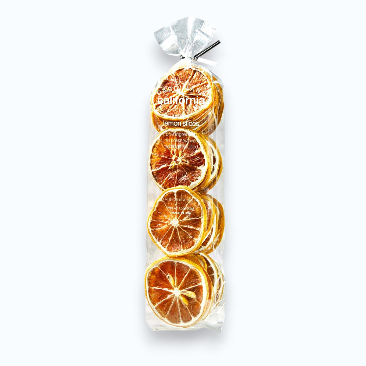 A clear bag containing several DARDIMANS - CRISPY LEMON SLICES by DARDIMANS CALIFORNIA CRISPS, stacked vertically. The bag is tied at the top with a transparent ribbon. Perfect as a vitamin C snack, this vegan and gluten-free treat is displayed against a light gray textured surface.