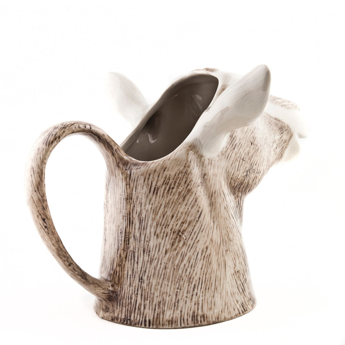 The QUAIL CERAMICS - GOAT JUG MEDIUM by QUAIL DESIGNS is a handpainted stoneware mug shaped like a goat’s head with detailed brown and white fur, upright ears, and a neck-shaped handle inspired by the British Toggenburg Goat jug.