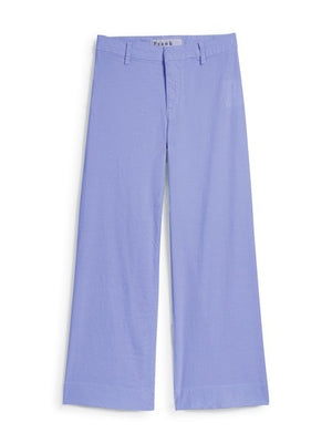 Woman standing and smiling, wearing a white t-shirt, FRANK & EILEEN Wexford Wide Leg Linen Pant in Wisteria, and white sneakers against a plain light background.