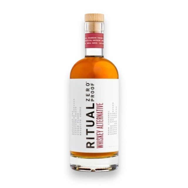 A clear bottle of RITUAL ZERO PROOF - WHISKEY ALTERNATIVE by RITUAL ZERO PROOF, featuring a tan cap and white label, filled with amber liquid and standing upright against a white background.