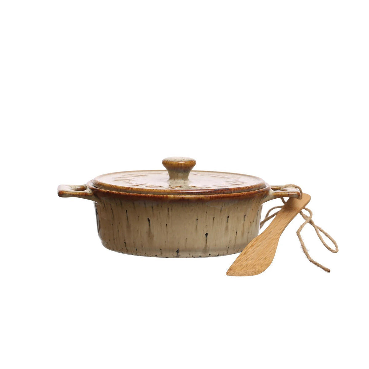 A Brie cheese sits in the CREATIVE COOP STONEWARE BRIE BAKER WITH LID AND BAMBOO SPREADER, topped with pear and honey. The lid is set aside, while a bamboo spreader and half a pear rest nearby on parchment paper.