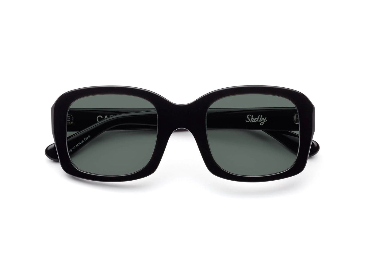 The CADDIS SHELPY Polarized Sunglasses feature a black, oversized square design with dark tinted lenses and a thick, glossy frame for a bold, modern look. Shown from the front on a white background.