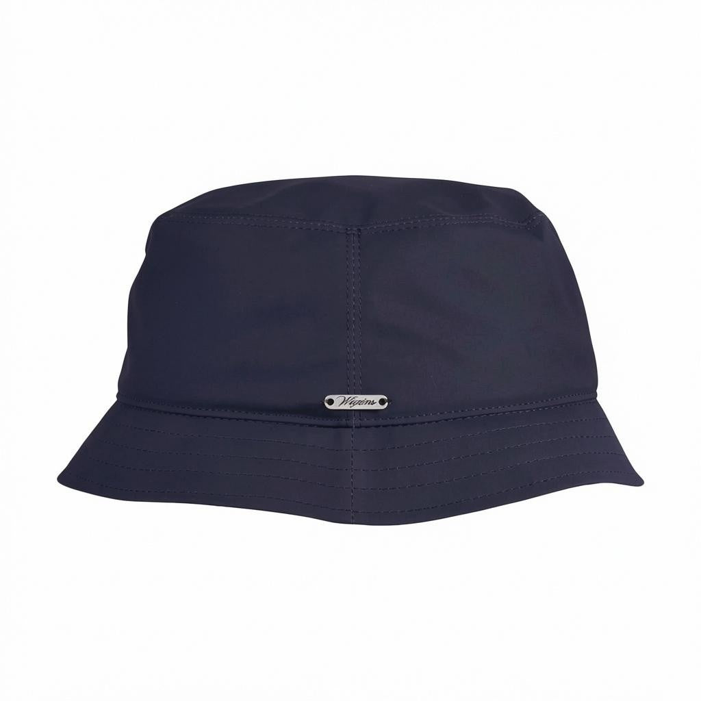 The WIGENS - Waxed Cotton Bucket Hat in Navy is a classic-style hat crafted from durable waxed cotton, featuring visible stitching and a small metallic tag on the front, shown against a white background.