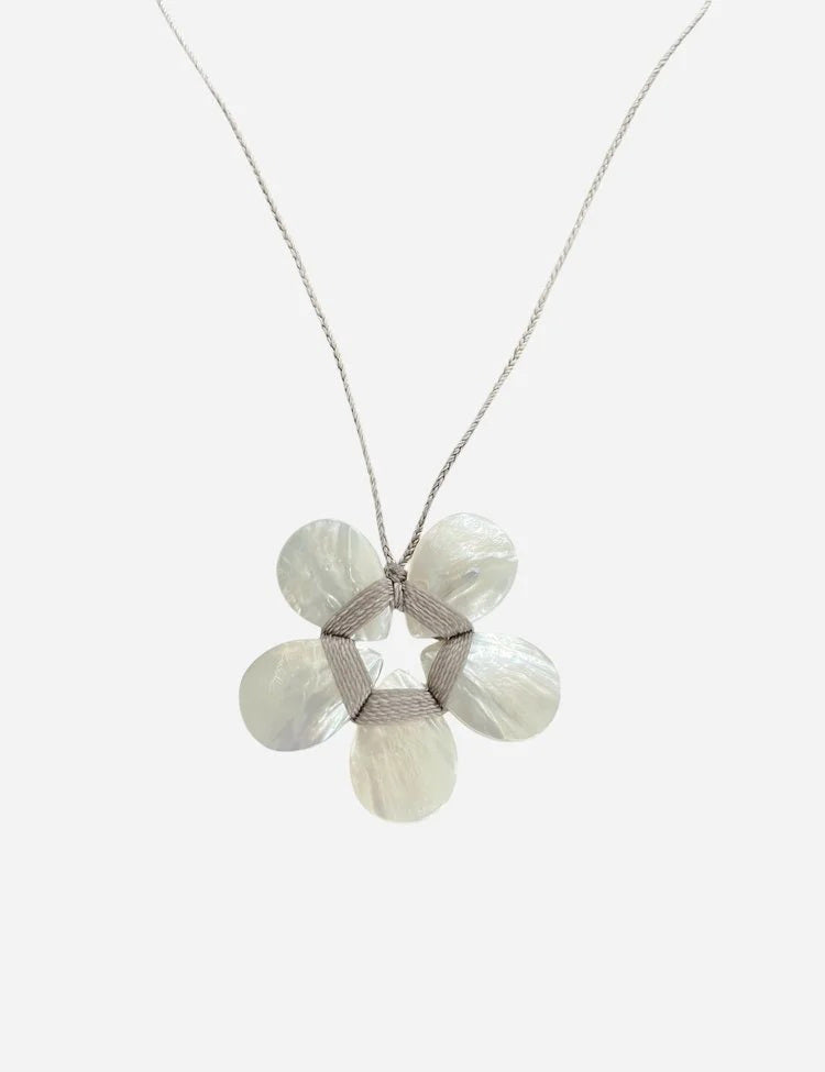 The ANN LIGHTFOOT - MOTHER OF PEARL FLOWER NECKLACE features a five-petal iridescent mother of pearl flower pendant on a simple gray background and includes an adjustable chain for the ideal fit.