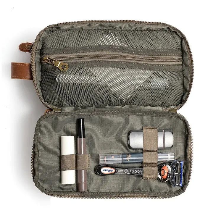 The TSD BRAND Turtle Ridge Toiletry Bag in Olive features leather accents and durable waxed canvas. Grooming essentials fit neatly in elastic loops and mesh pockets, making it the perfect travel companion.