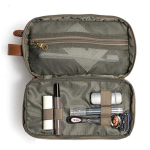 The TSD BRAND Turtle Ridge Toiletry Bag in Olive features leather accents and durable waxed canvas. Grooming essentials fit neatly in elastic loops and mesh pockets, making it the perfect travel companion.