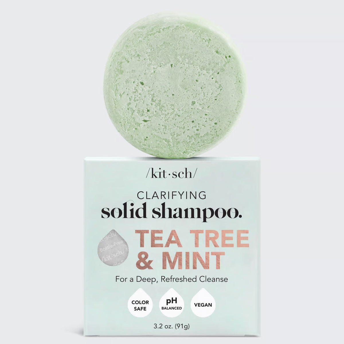 A light green KITSCH solid shampoo bar sits atop its packaging marked "TEA TREE &amp; MINT CLARIFYING SHAMPOO BAR, For a Deep, Refreshed Cleanse." Infused with tea tree oil, as a 4ocean Certified Cleanup Partner, KITSCH helps reduce single-use plastic.