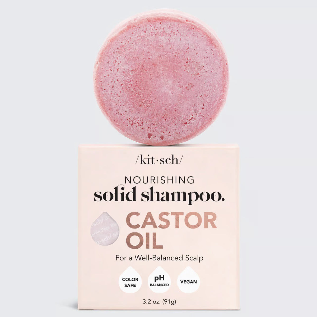 The pink KITSCH - CASTOR OIL SHAMPOO BAR is 3.2 oz (91g) of eco-friendly, color-safe, pH-balanced, vegan, and plastic-free hair care. Ideal for those seeking balance and sustainability with its "Nourishing Solid Shampoo" label for a well-balanced scalp.