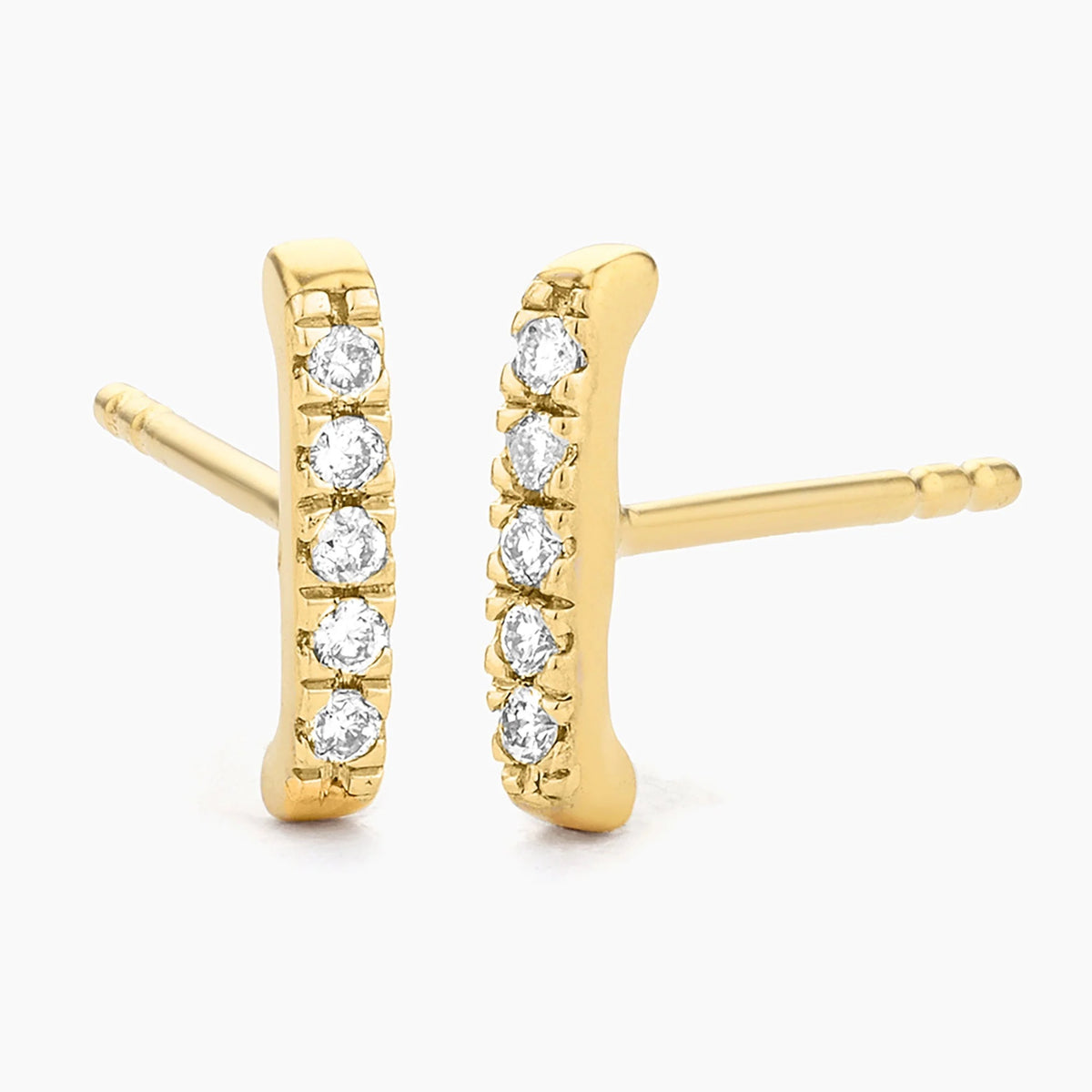The ELLA STEIN - AMA STUD EARRINGS by ELLA STEIN feature a sleek vertical bar design, each set with five round white gemstones in a row. Crafted from waterproof stainless steel and finished with gold plating, these earrings shine elegantly against a plain white background.