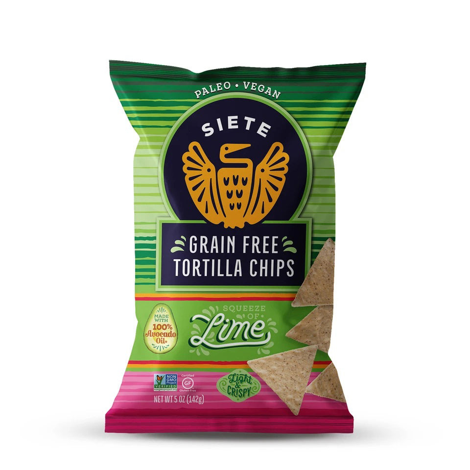 A vibrant bag of SIETE - LIME TORTILLA CHIPS from SIETE FOODS features a green and pink design with an eagle logo. It's proudly paleo, vegan, made with 100% avocado oil, and displays two lime chips peeking out from the top.