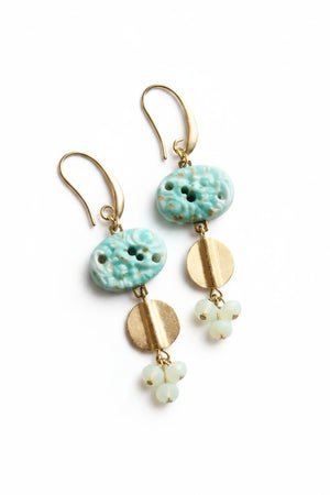 The DAVID AUBREY - VINTAGE TURQUOISE GLASS CLUSTER EARRINGS by DAVID AUBREY feature gold plated ear wires, turquoise glass beads, round gold accents, and delicate clusters of small white beads, beautifully displayed on a round white surface.