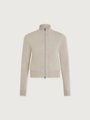 A person wears a light beige Varley Rufus Cropped Zip Through Sweat in Pebble Marl with a high collar and matching pants.