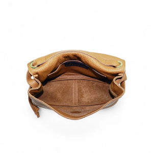 Side view of the OLIVEVE Remi Medium Slouchy Shoulder Bag in Miel Buffalo Cowhide, showcasing its luxurious Italian buffalo cowhide leather, single crossbody strap, visible drawstring, and textured surface against a plain white background.