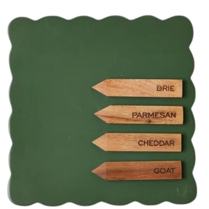 The ETUHOME Green Square Scalloped Cheese Board with Markers displays six savory herb tarts arranged in a circle around a glass dip bowl, resting on a beige napkin with two forks on a marble surface.