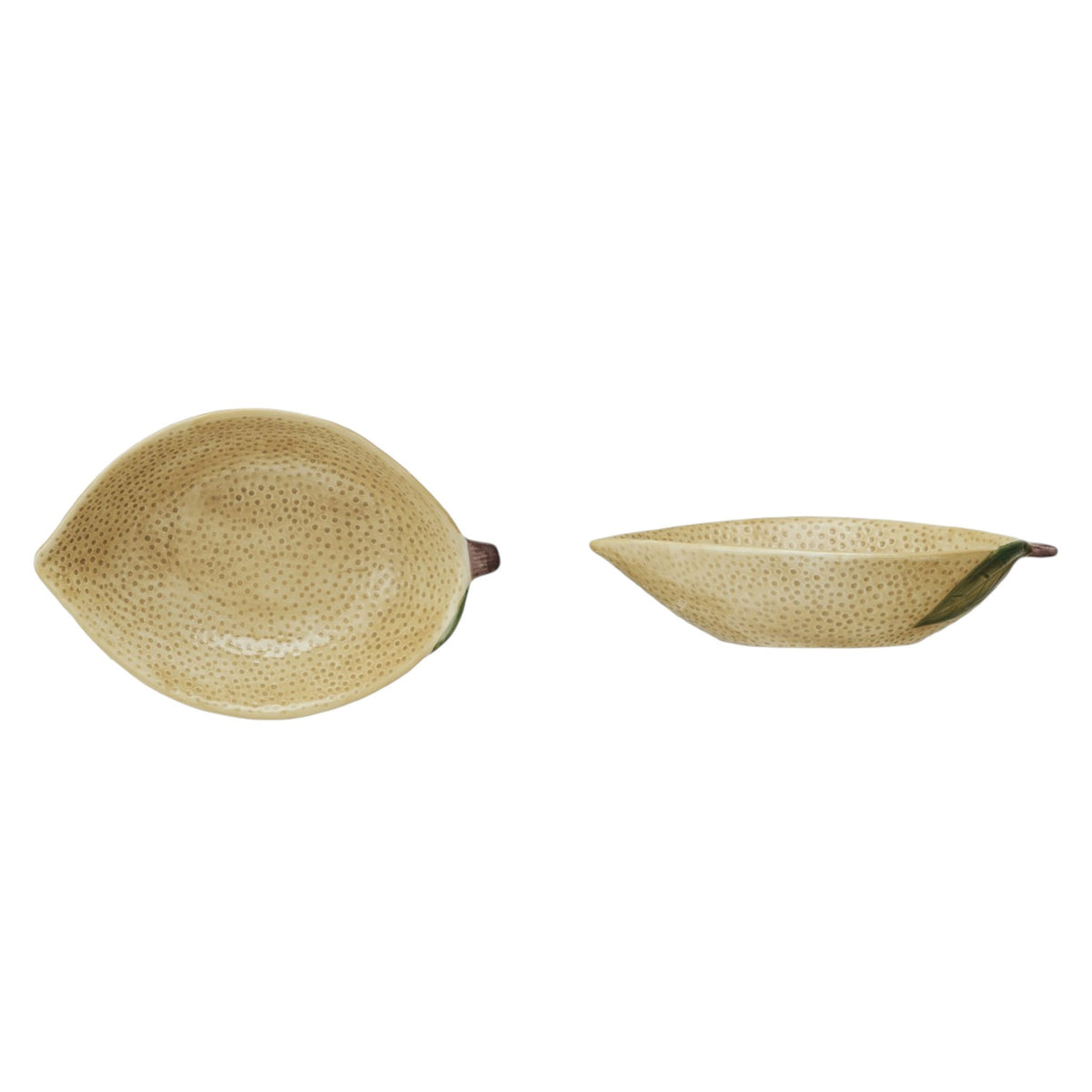 A flat lay features CREATIVE COOP’s HAND-PAINTED STONEWARE LEMON SHAPED BOWL, SMALL—one with oats, one with a grapefruit—plus a lemon-shaped pitcher and ceramic lemons atop a folded striped cloth. A delightful citrus-themed display.