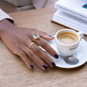 A bottle of MANUCURIST INC GREEN™ Nail Polish in Eggplant, featuring a rich dark purple shade visible through the glass and labeled as “green” and “quick dry intense color.”.