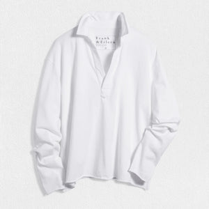 The FRANK & EILEEN Patrick Popover Henley in Heritage Jersey White, a relaxed-fit long-sleeve shirt with an open neckline, is shown laid flat on a textured white surface. The tag displays the FRANK & EILEEN brand name.