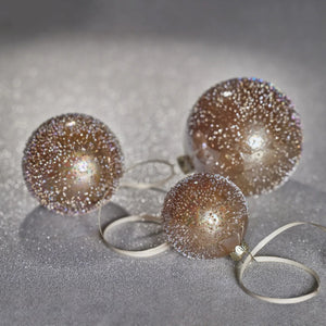 A ZODAX GOLDEN SUGAR BEAD GLASS BALL, a 12.07 cm diameter spherical glass Christmas ornament covered in gold-toned beads, hanging from a thin gold ribbon.