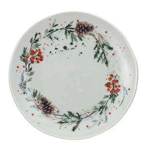 Three CREATIVE COOP STONEWARE PLATES WITH SEASONAL BOTANICALS—a round plate with a gold cheese knife, a triangular plate, and a long oval plate with cookies—display berry and floral designs on a light textured surface.