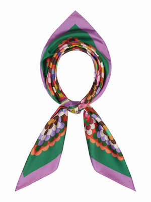 A vibrant quilt showcases geometric squares in pink, red, green, brown, white, and black with green and red borders—each echoing the bold design of the FRANCO FERRARI - CIALDA REVERSIBLE SILK SCARF by FRANCO FERRARI.