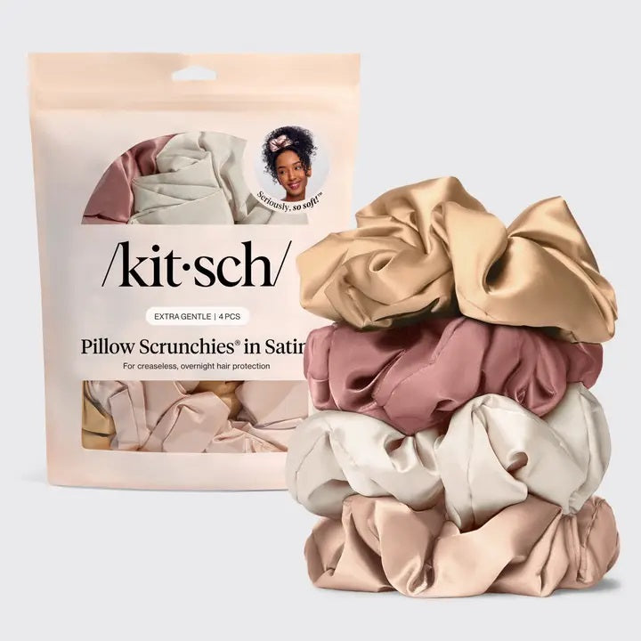 The KITSCH - PILLOW SATIN SCRUNCHIES IN BLUSH by KITSCH, shown in a circular arrangement with a subtle fabric tag on a light gray background, provide frizz control as a gentle, damage-free hair accessory.