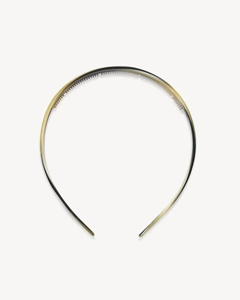 The MACHETE Ultralight Thin Headband in Horn is a slender, curved Italian acetate headband showcasing a marbled pattern in black, gray, cream, and light brown hues. Lightweight and designed for all hair types, it is displayed against a plain white background.