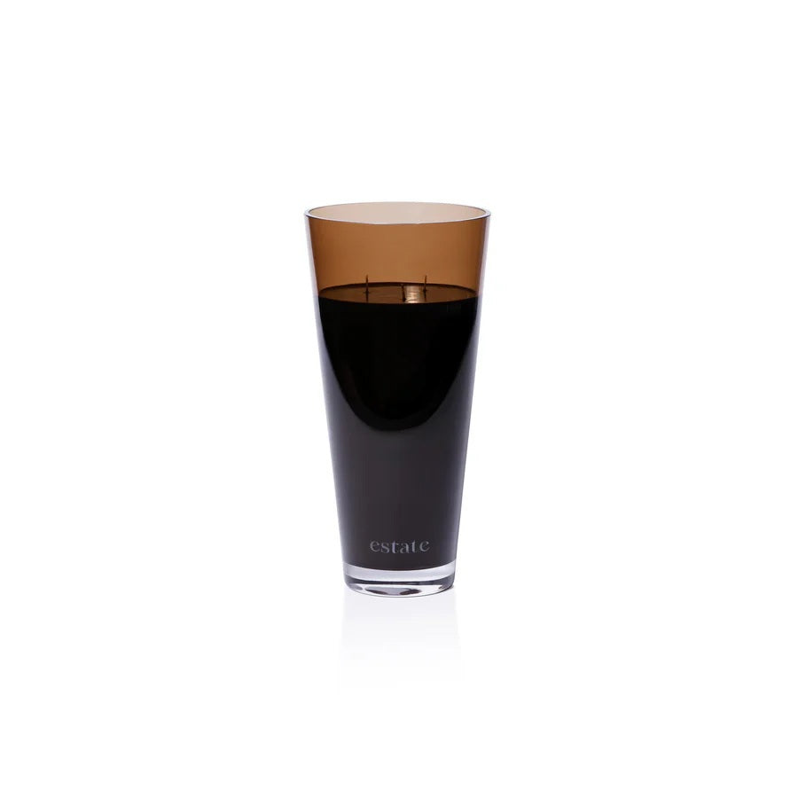 A collection of ZODAX luxury scented candles, including the 57 OZ THISTLE ESTATE CANDLE in black and smoky brown, is displayed on a white textured surface against a plain light background.