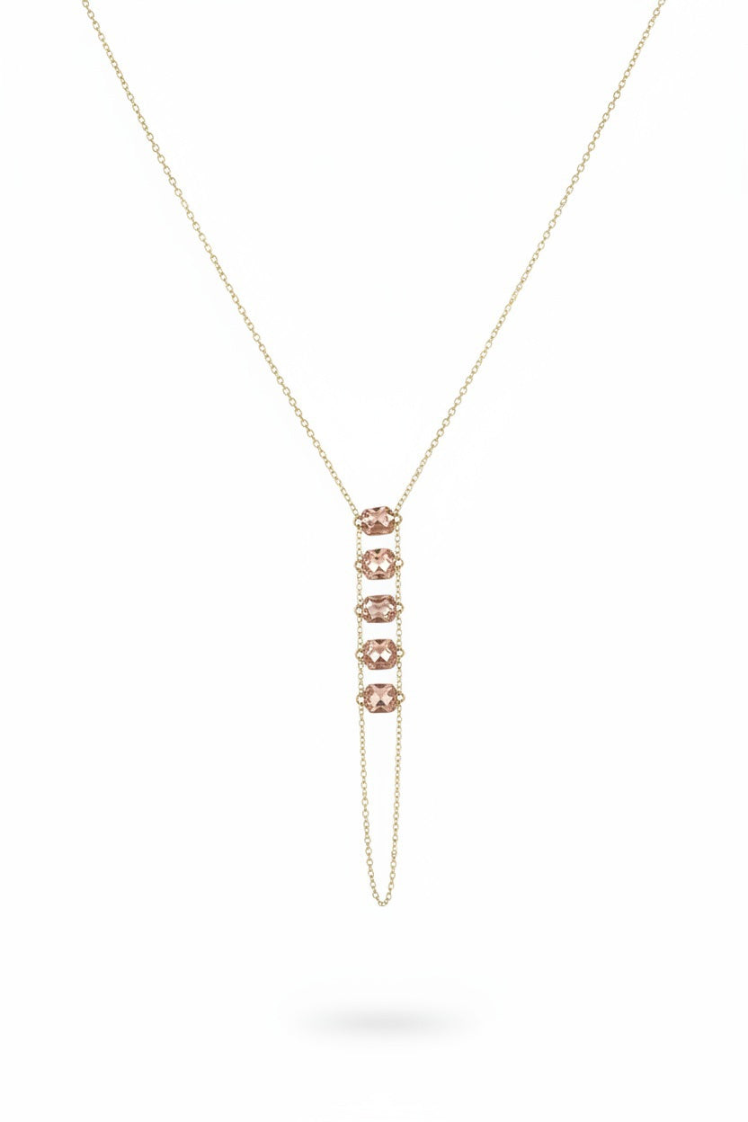 The GOLDISH - LADDERS TO BLISS PINK MOONSTONE NECKLACE features a gold vertical pendant with five pink moonstones, displayed on a beige textured bust against a white background, representing balance and harmony from GOLDISH.