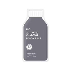 A bottle of ESW BEAUTY - H2O Charcoal Lemon Juice Mask sits on a white surface with lemon halves, a whole lemon, a bowl of white powder, a wooden spoon, and ESW Beauty’s black charcoal powder.