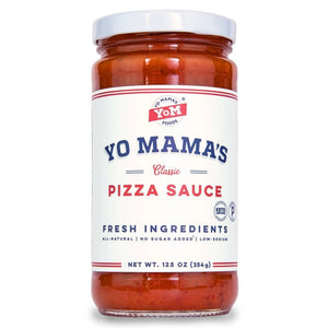 A clear glass jar of YO MAMA'S FOODS PIZZA SAUCE with a white lid showcases the No Added Sugar, keto-certified red sauce. The side label lists ingredients, nutrition facts, social media icons, and a bar code.