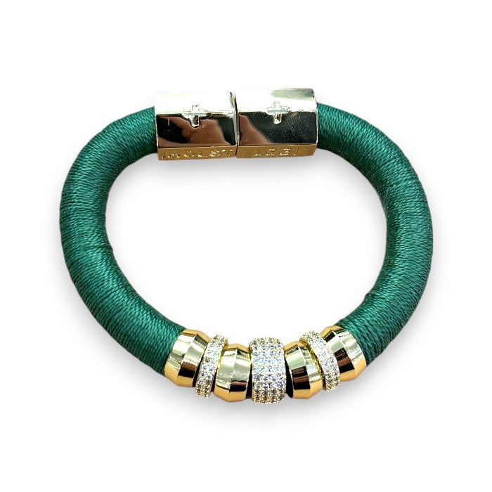 The HOLST + LEE - LUXE CLASSIC BRACELET by HOLST &amp; LEE features an elegant orange cord with gold-plated accents, including a rectangular gold clasp adorned with several gold and diamond-encrusted beads near the clasp.