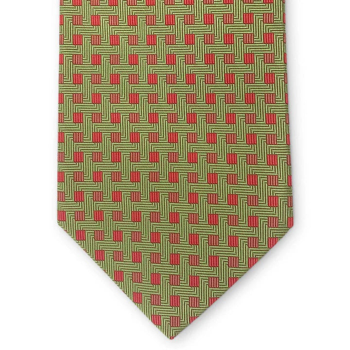 The PETER-BLAIR Bespoke Small Squares Silk Tie in Green by BIRD DOG BAY features a geometric red square pattern and is handmade in New York, shown rolled up on a white surface.