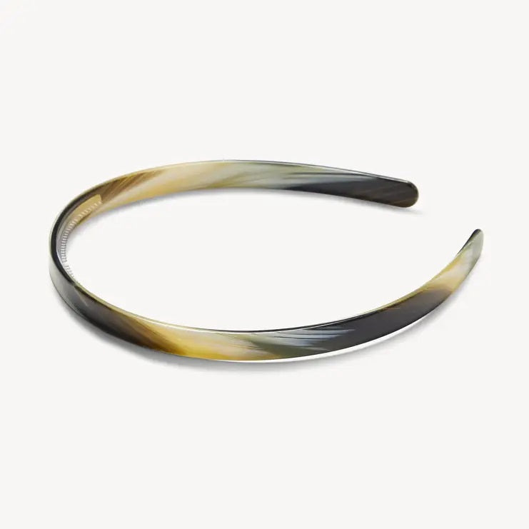 The MACHETE Ultralight Thin Headband in Horn is a slender, curved Italian acetate headband showcasing a marbled pattern in black, gray, cream, and light brown hues. Lightweight and designed for all hair types, it is displayed against a plain white background.