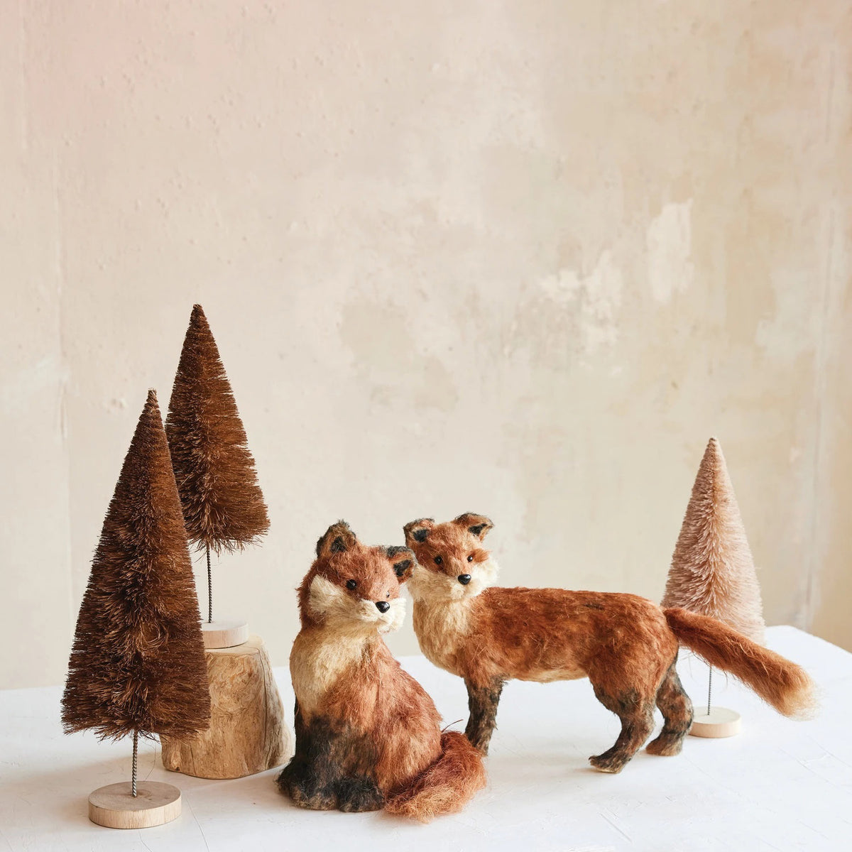 The CREATIVE COOP SISAL SITTING FOX features reddish-brown fur, black-tipped ears, a bushy tail, and tan accents—an adorable plush decor piece for any space.