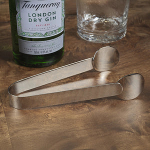 The ZODAX SPIGA TEXTURED ICE TONGS NICKEL, featuring flat, rounded ends and a textured grip, are 7-inch stainless steel tongs made from durable alloy material, shown resting on a white surface.