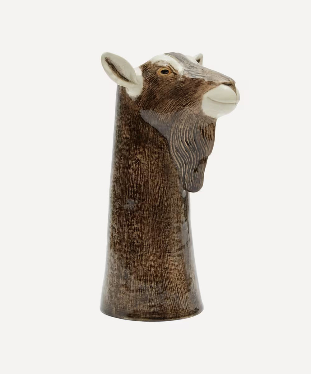 The QUAIL DESIGNS QUAIL CERAMICS - GOAT FLOWER VASE is a hand-painted ceramic vase shaped like a goat's head with brown and white details, upright ears, and realistic features, shown on a plain white background.