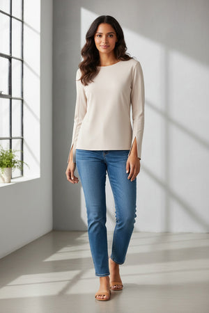 The SEVENTY Stretch Crewneck Viscose Top with Sleeve Detail is a light beige, long-sleeve shirt featuring a simple and elegant design. Made in Italy, this sophisticated top has slightly flared sleeves with subtle slits near the cuffs and a relaxed fit. Crafted from stretch viscose cady, it hangs straight for a minimalistic and refined appearance.