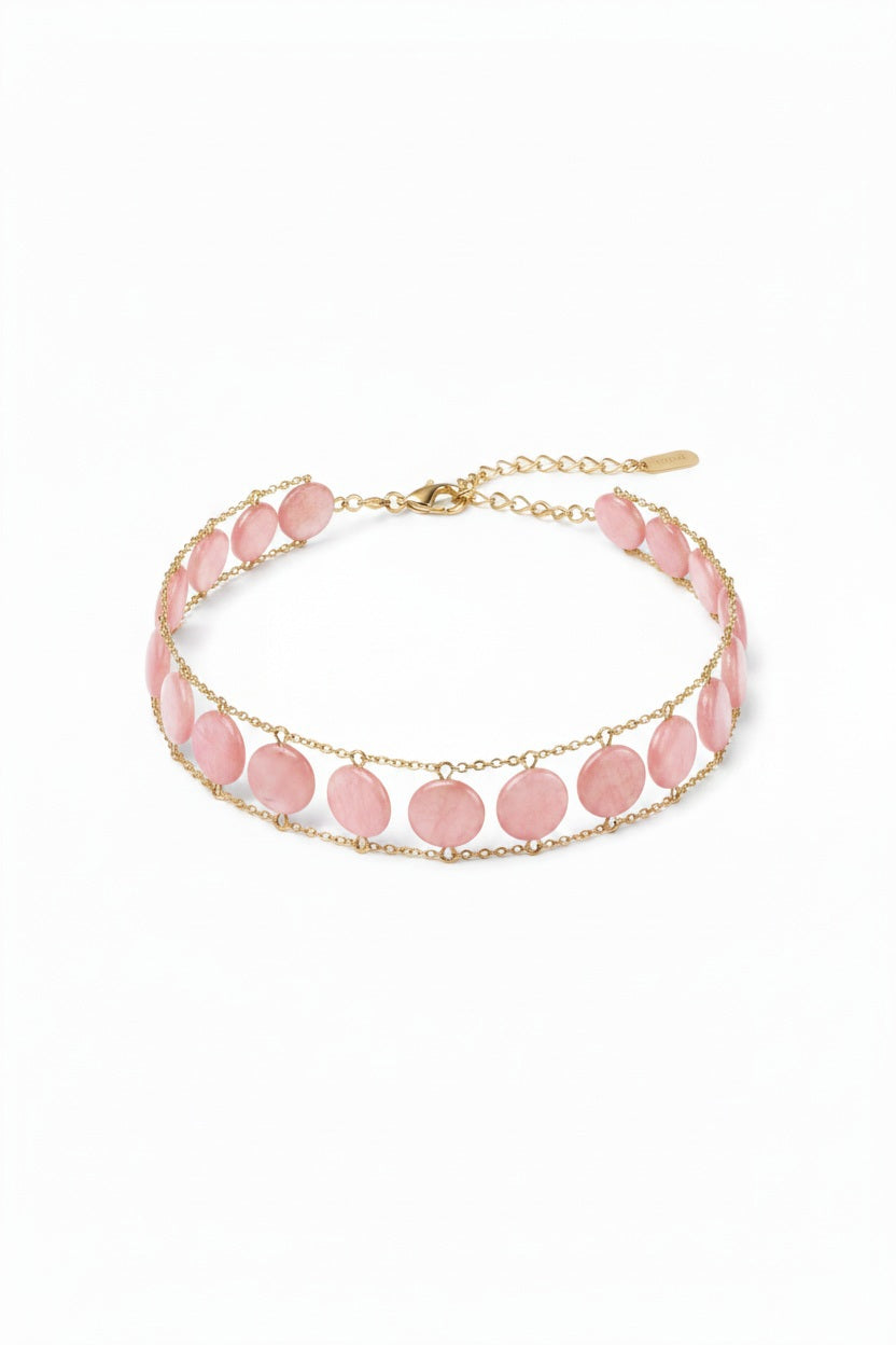 A close-up of a woman's neck wearing the GOLDISH Ladders to Bliss Pink Moonstone Choker, featuring two rows of round moonstones set in gold-toned chain links, by GOLDISH, against a neutral background.